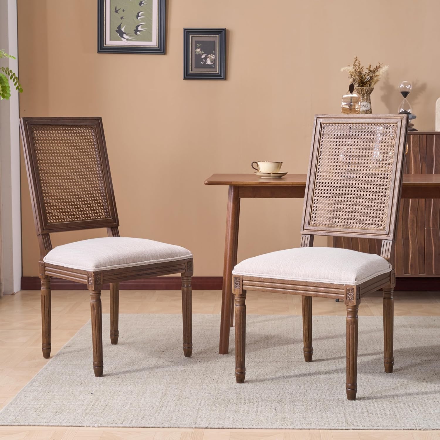 Two dining chairs with fluted walnut legs and handwoven cane backrests shown on a neutral rug and light hardwood floor