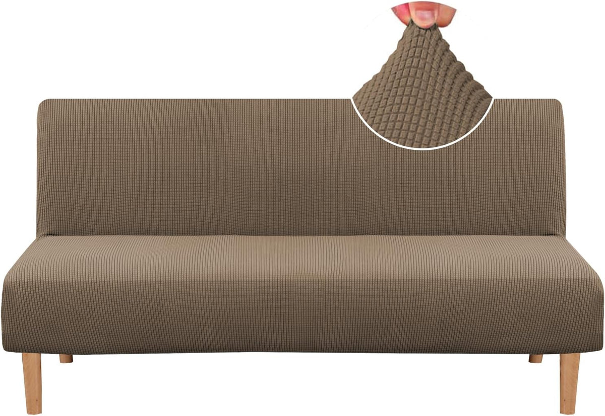 Front view of a slim armless sofa covered in a taupe small-check textured slipcover with wood legs