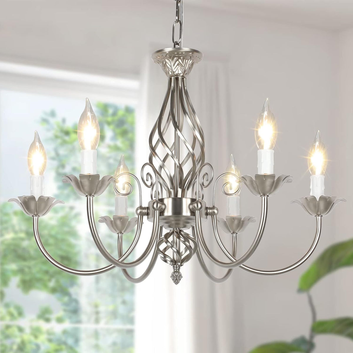 Silver-finished six-arm chandelier with lit candle bulbs hanging in a bright room