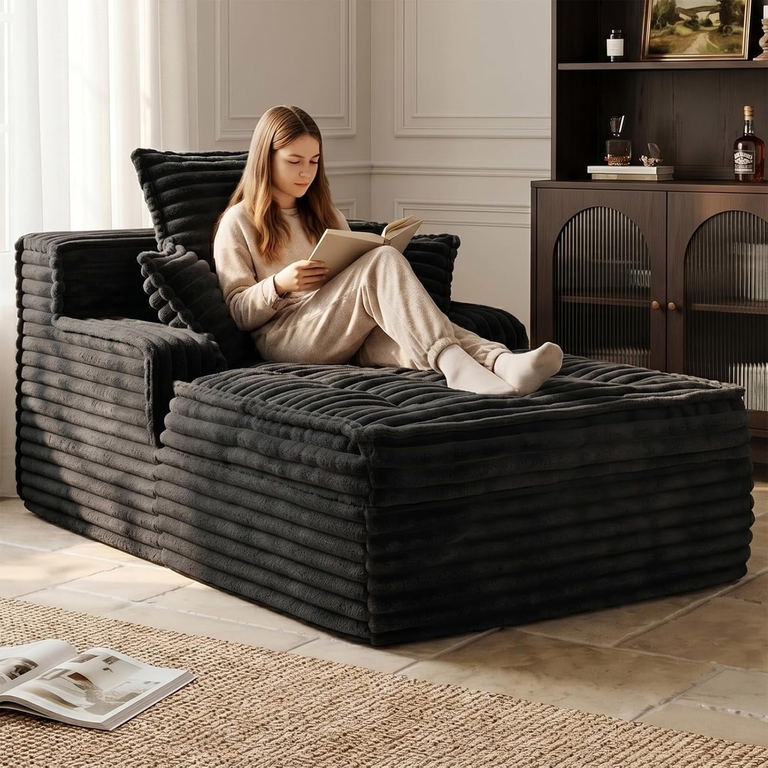 Side view of the ribbed corduroy chaise with girl reclining and reading
