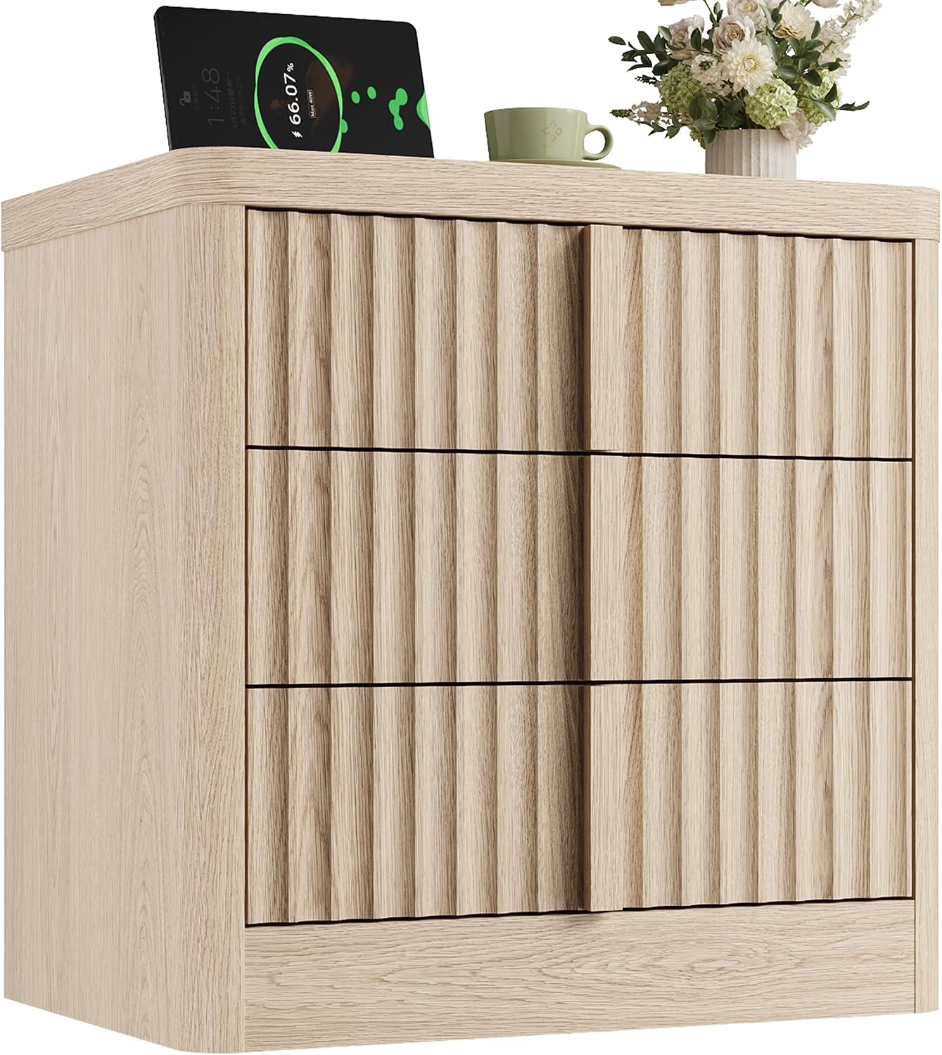 Close-up of light-wood nightstand corner showing fluted drawer fronts and tabletop items