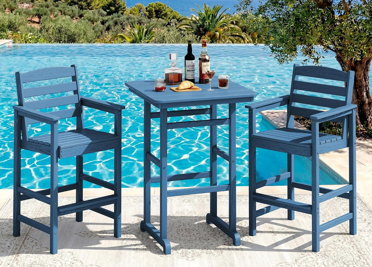 Three-piece blue bar-height set beside a pool: two armchairs flanking a square pub table with drinks on top.