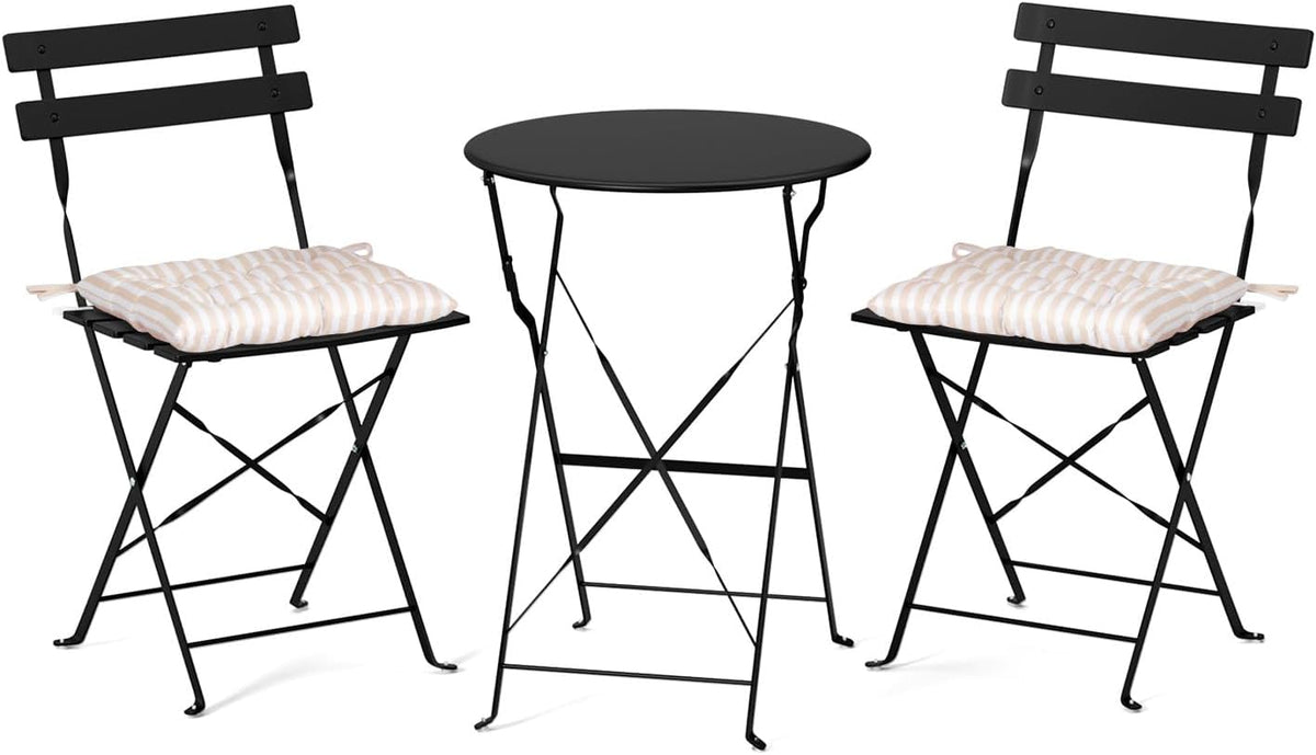 Black folding bistro table centered between two black folding chairs, each fitted with a beige-striped seat cushion.