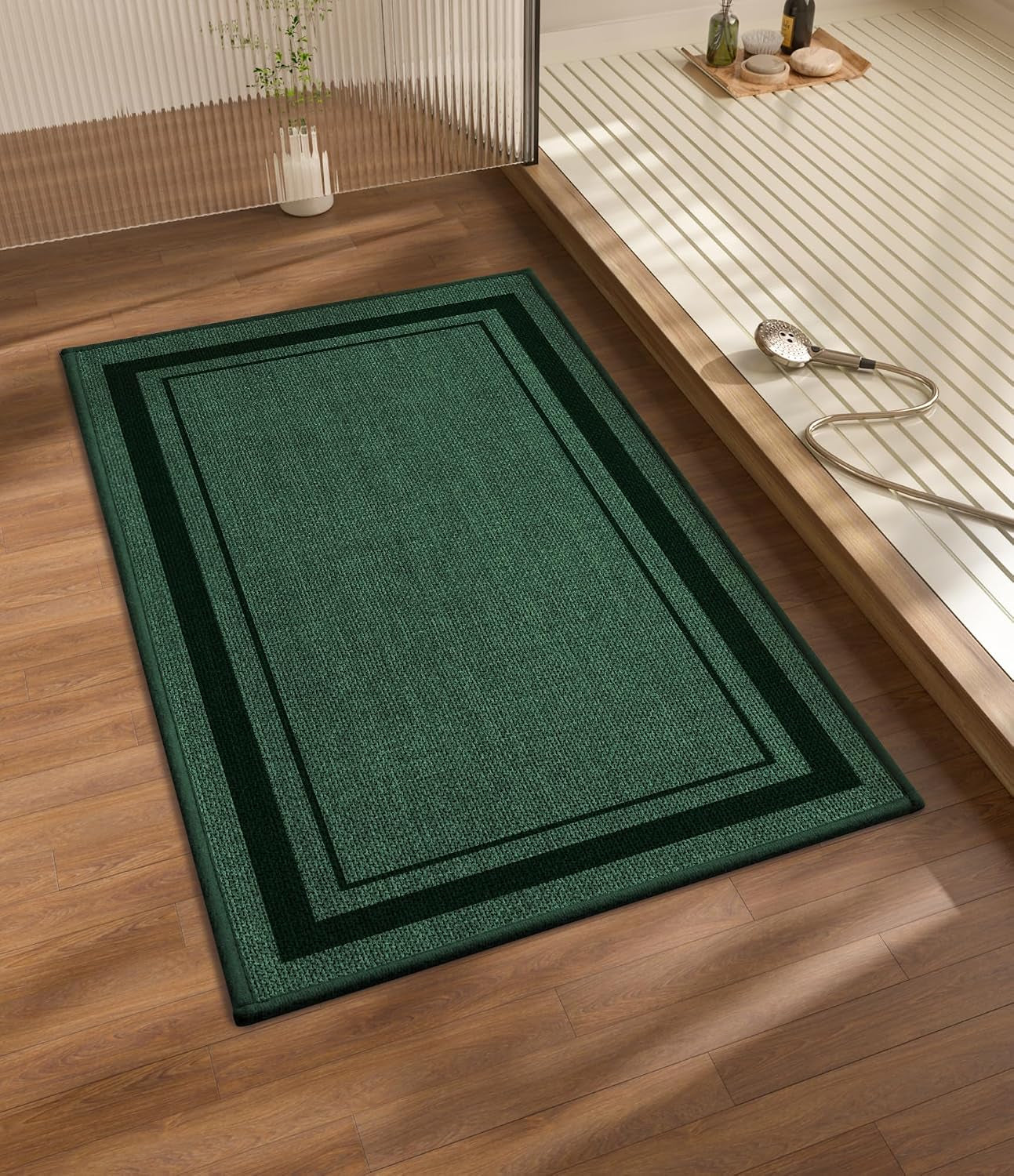 Dark green rectangular bath rug beside a raised tub platform and handheld shower head
