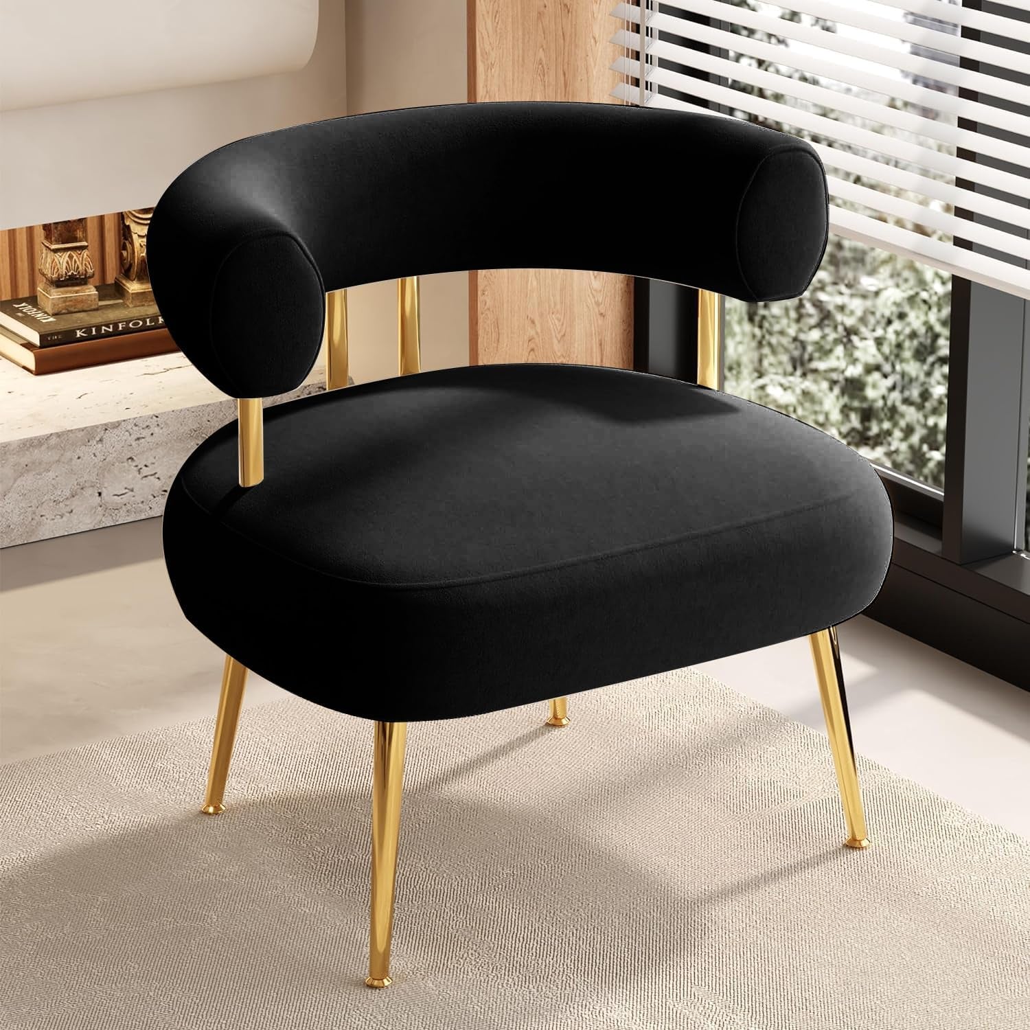 Black round barrel accent chair with gold metal legs staged near a window on a light rug.