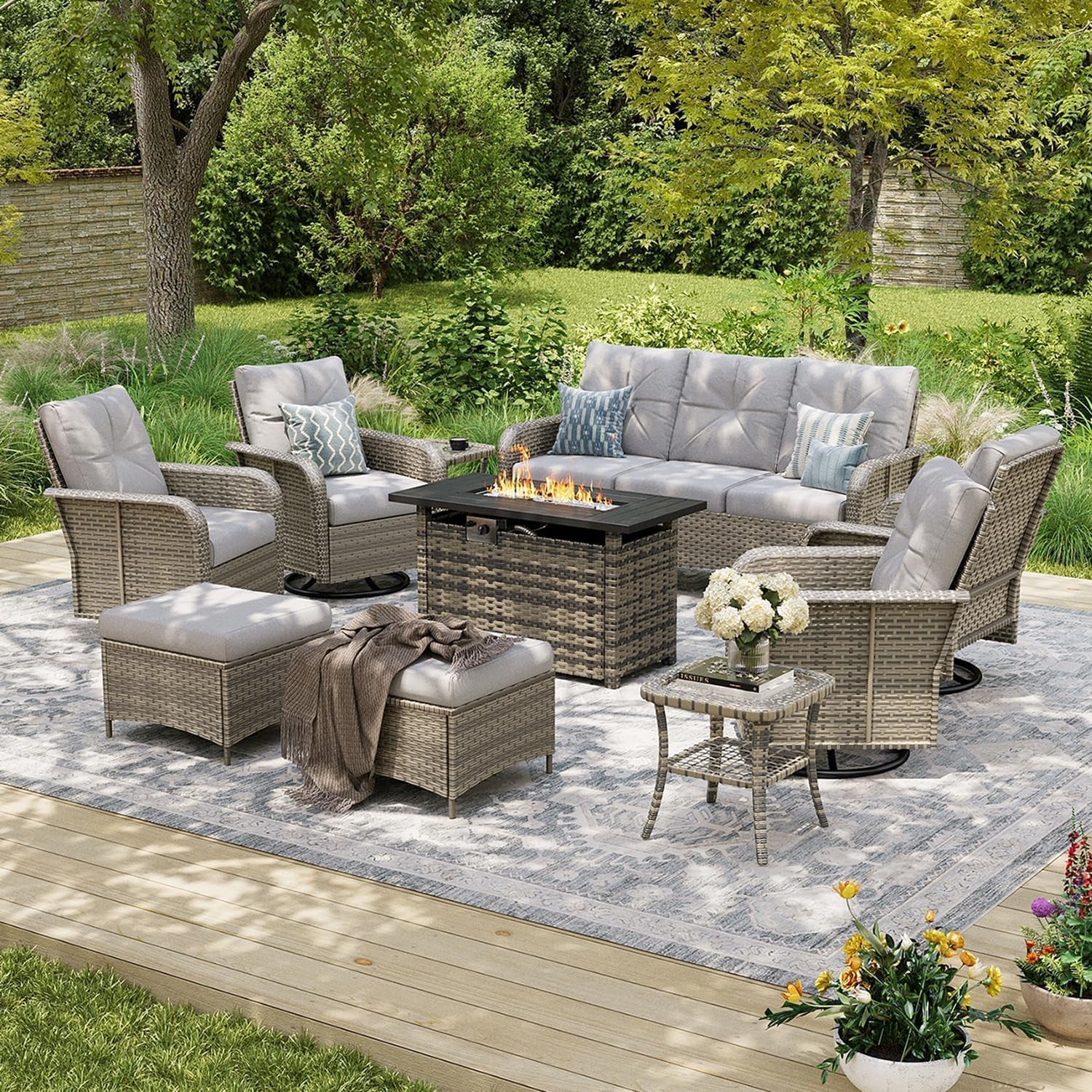 Patio set in a lighter wicker finish with light gray cushions, ottomans and a center fire pit table