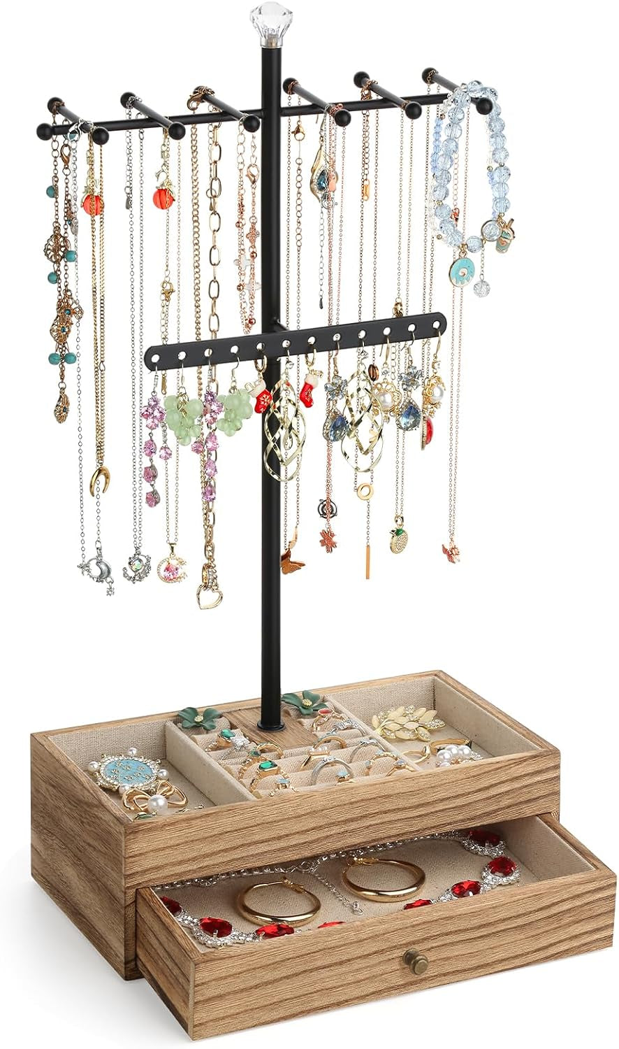 Side angle showing the black metal three-tier tree topped with a faceted crystal finial standing in a light wood two-drawer