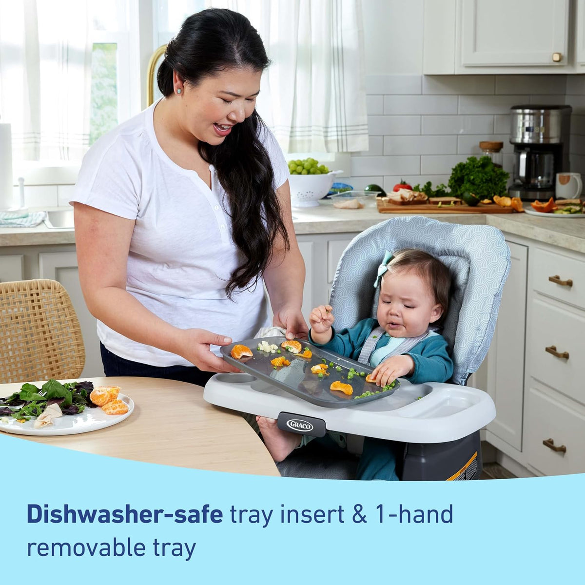 caregiver removes a highchair tray while a baby sits in the chair with bits of food on the tray
