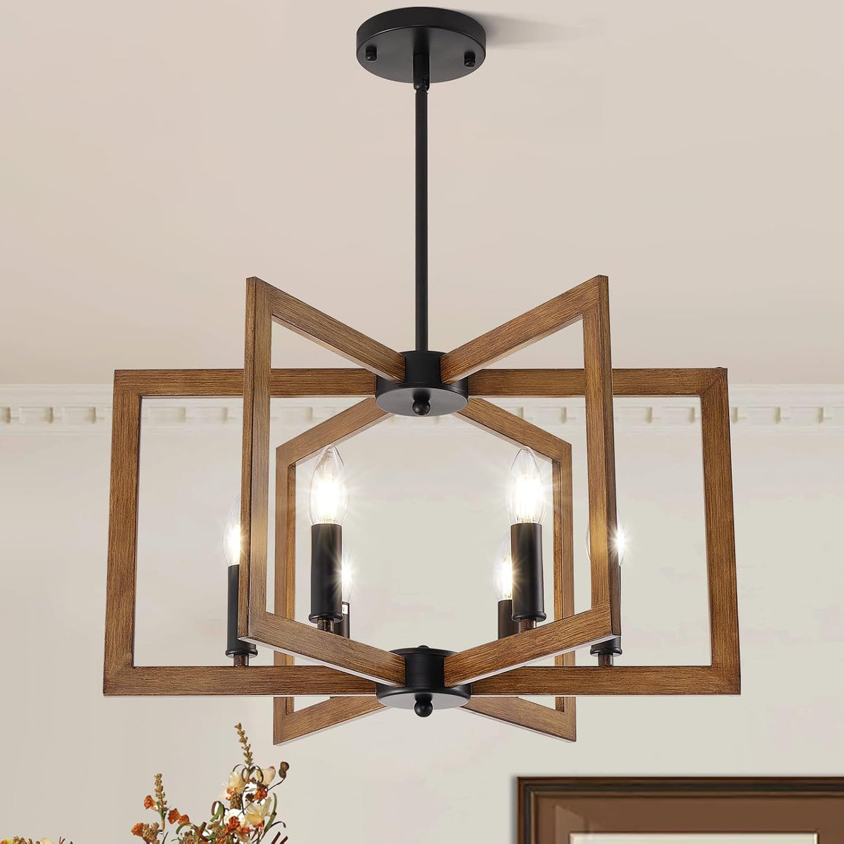 Angled view of intersecting wood frames forming a geometric chandelier around candle-style bulbs.