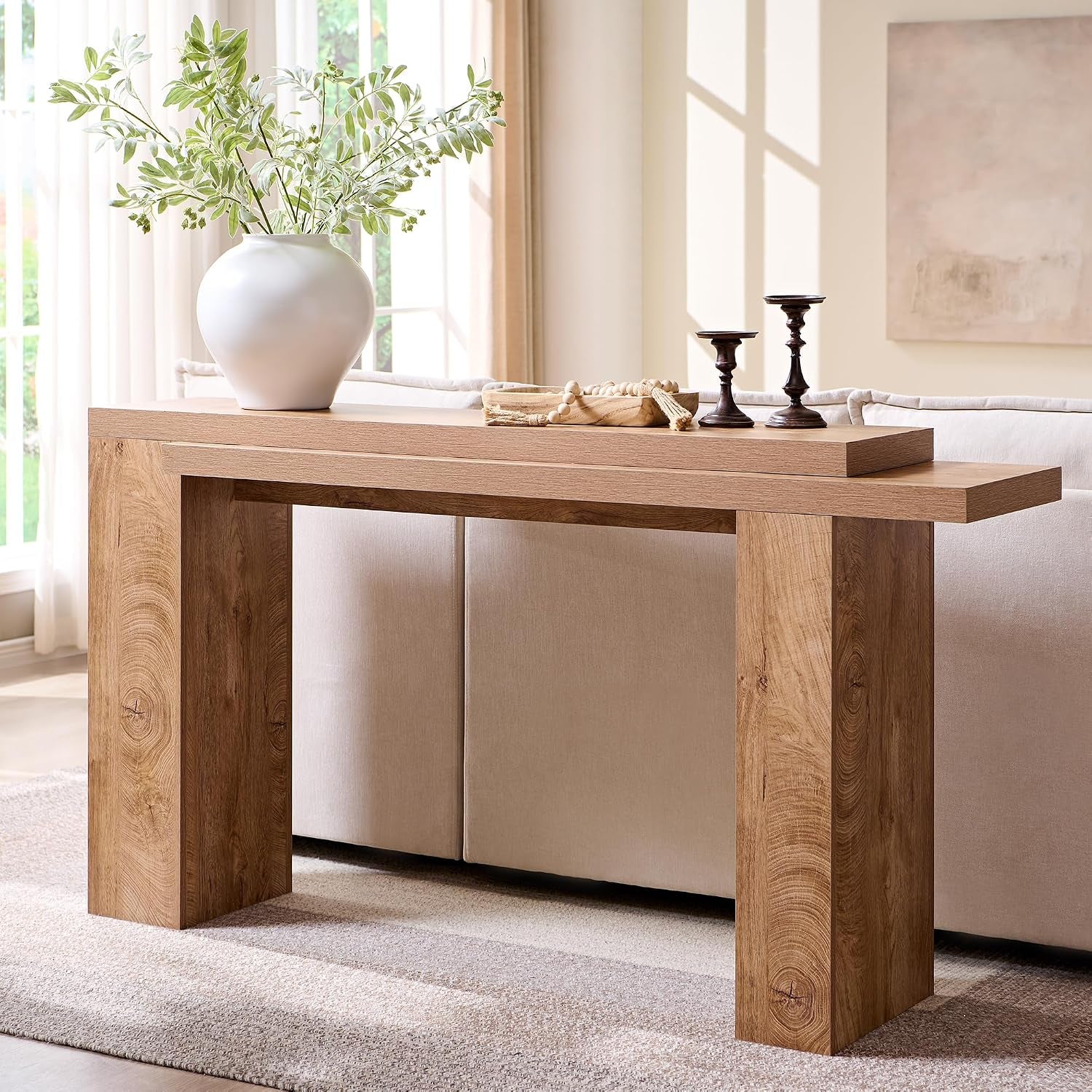 Back view of the console table positioned behind a sofa highlighting the layered tabletop in light tree knot finish