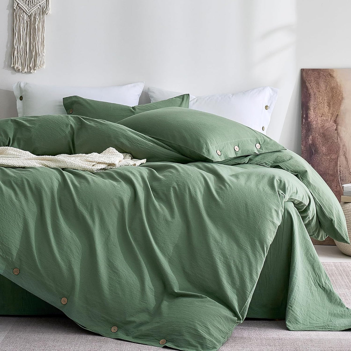 Angled close view of a sage green duvet and matching pillow with visible round wooden buttons along the hem