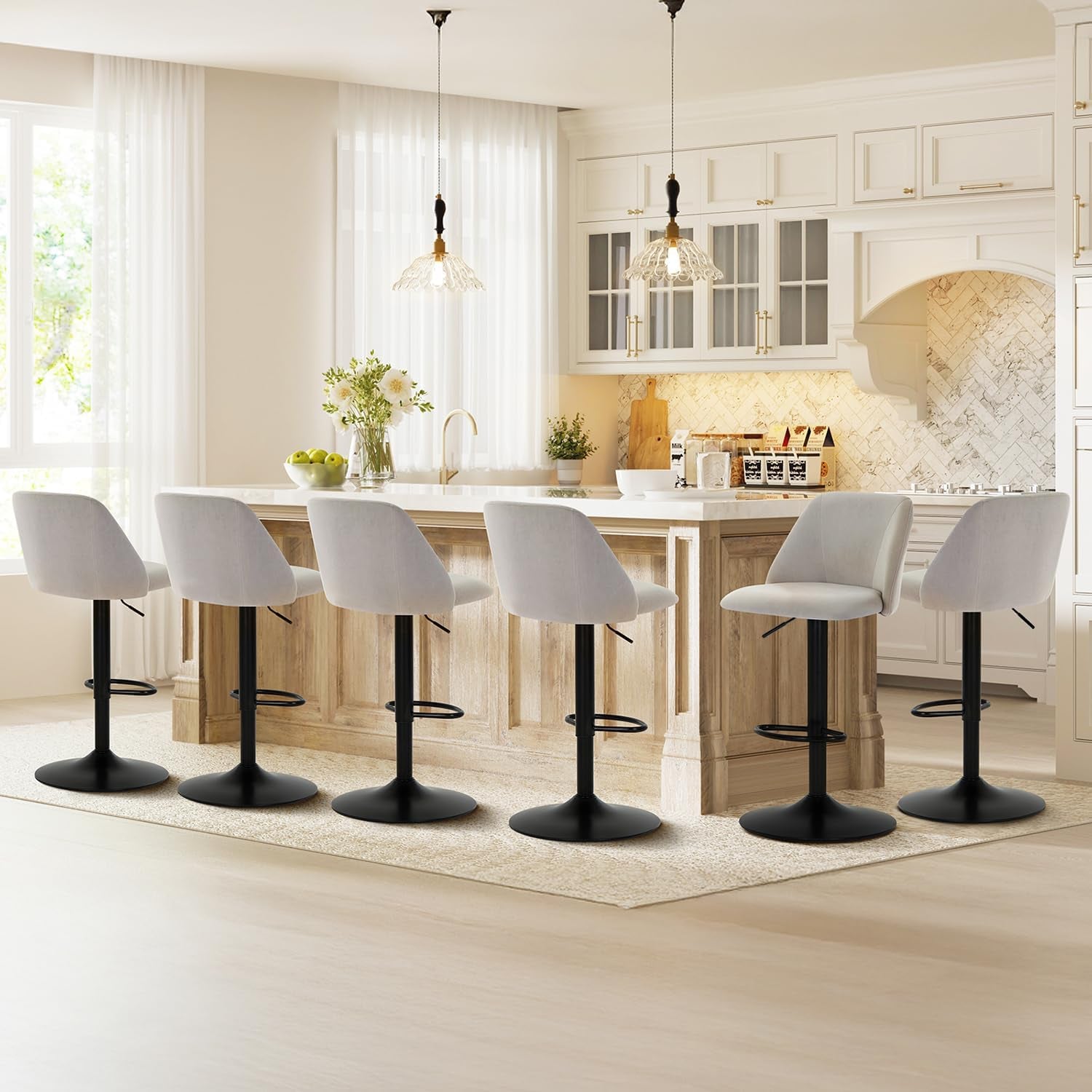 Six light-gray fabric swivel bar stools arranged along a bright kitchen island