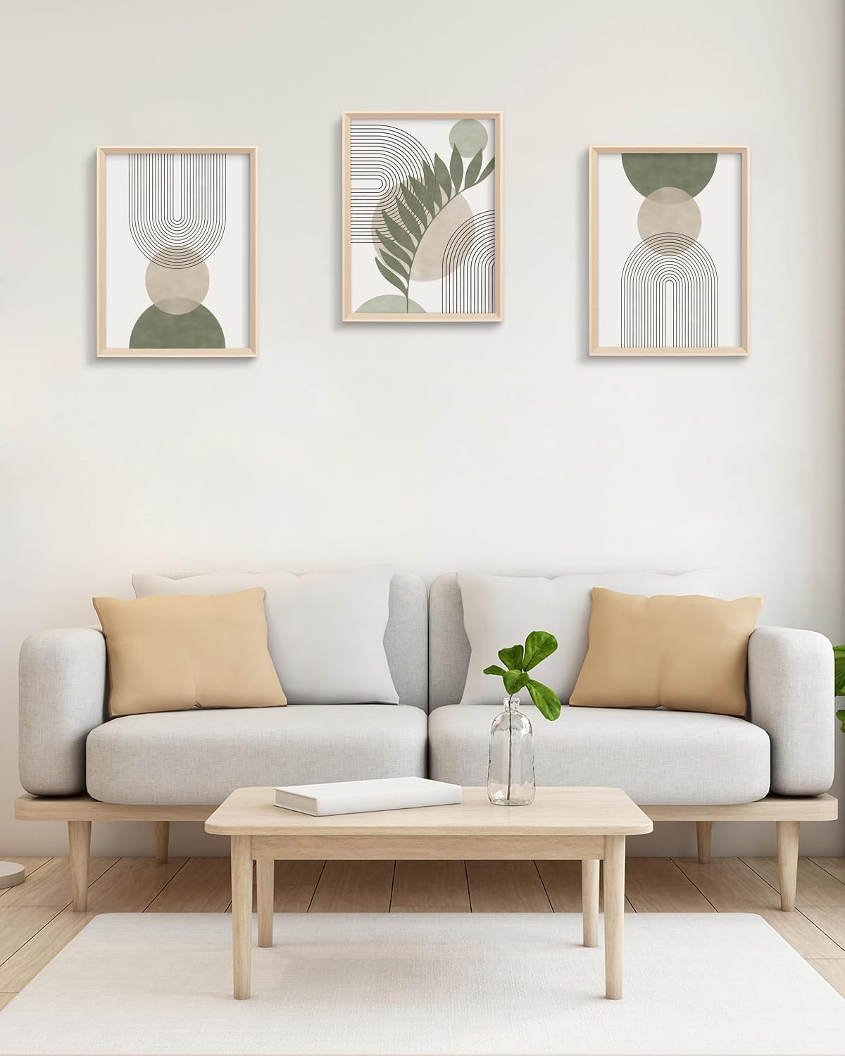 Three framed green-and-beige abstract prints aligned horizontally above a light grey sofa
