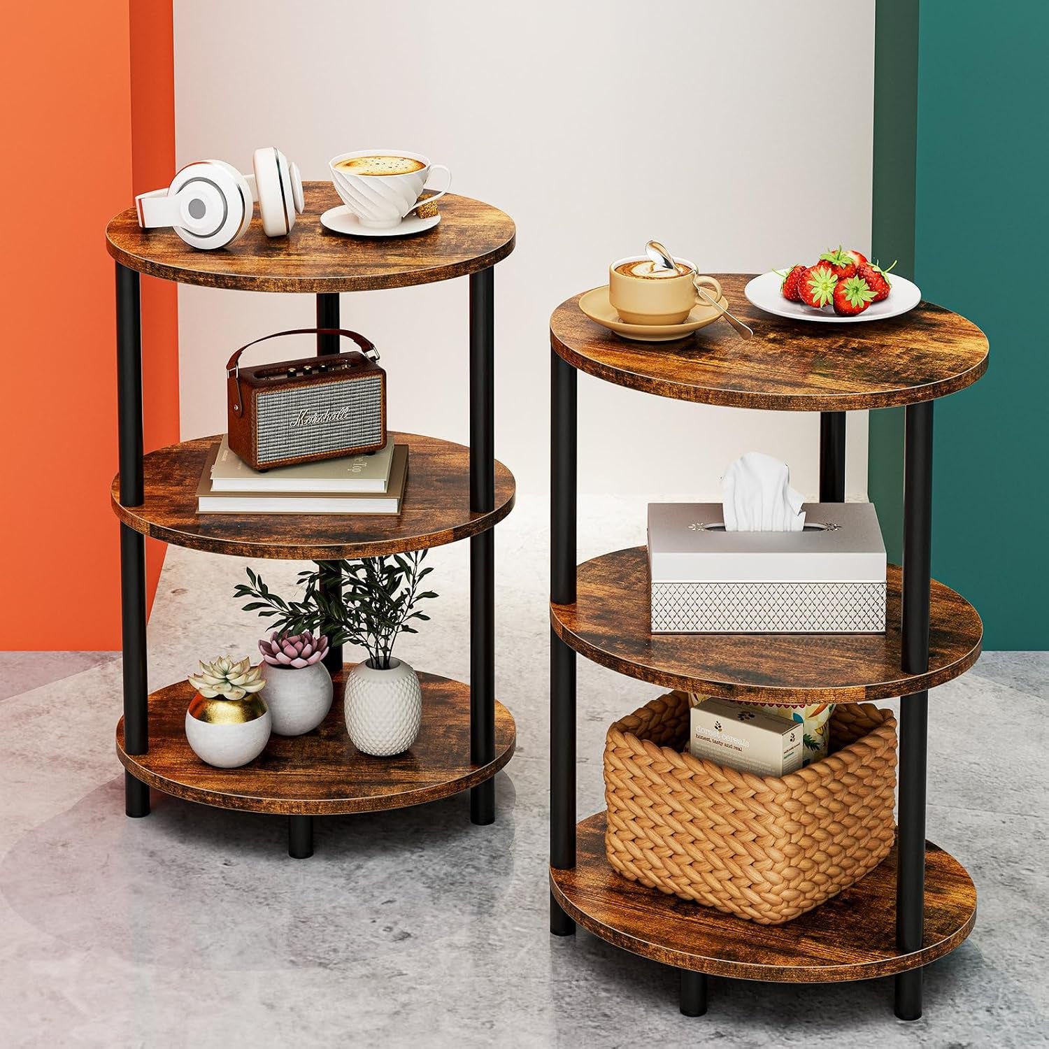 Pair of round three-shelf end tables with distressed brown tops and black legs holding cups, tissue box and basket