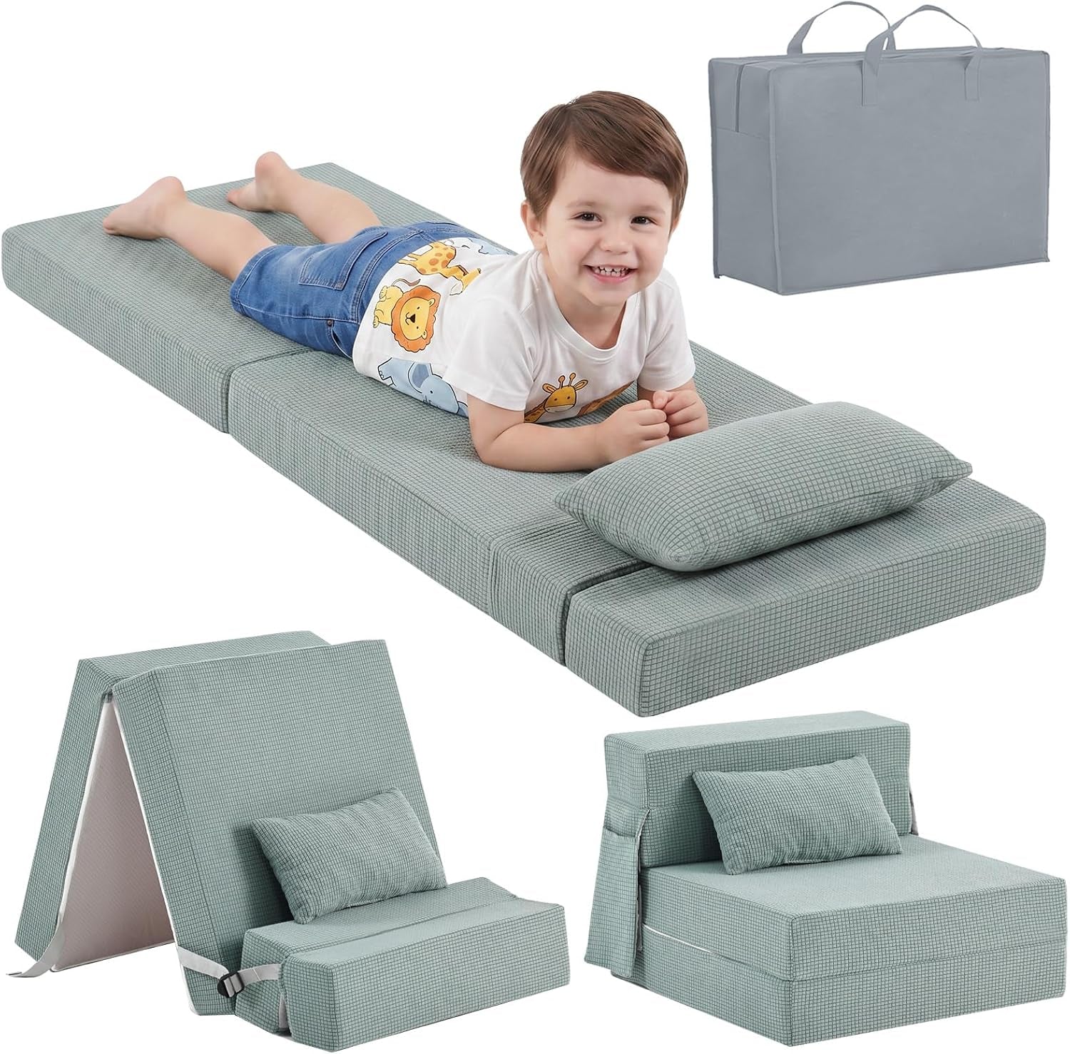 Smiling child lying on a sage green checkered folding floor mattress with pillow and storage bag.