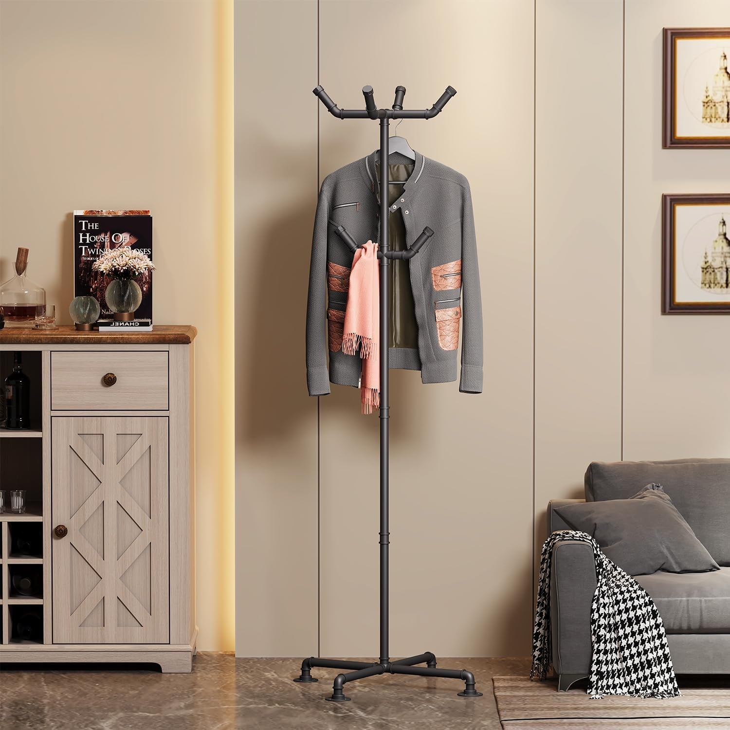 Black pipe coat rack in a living room scene beside a cabinet and sofa, front view