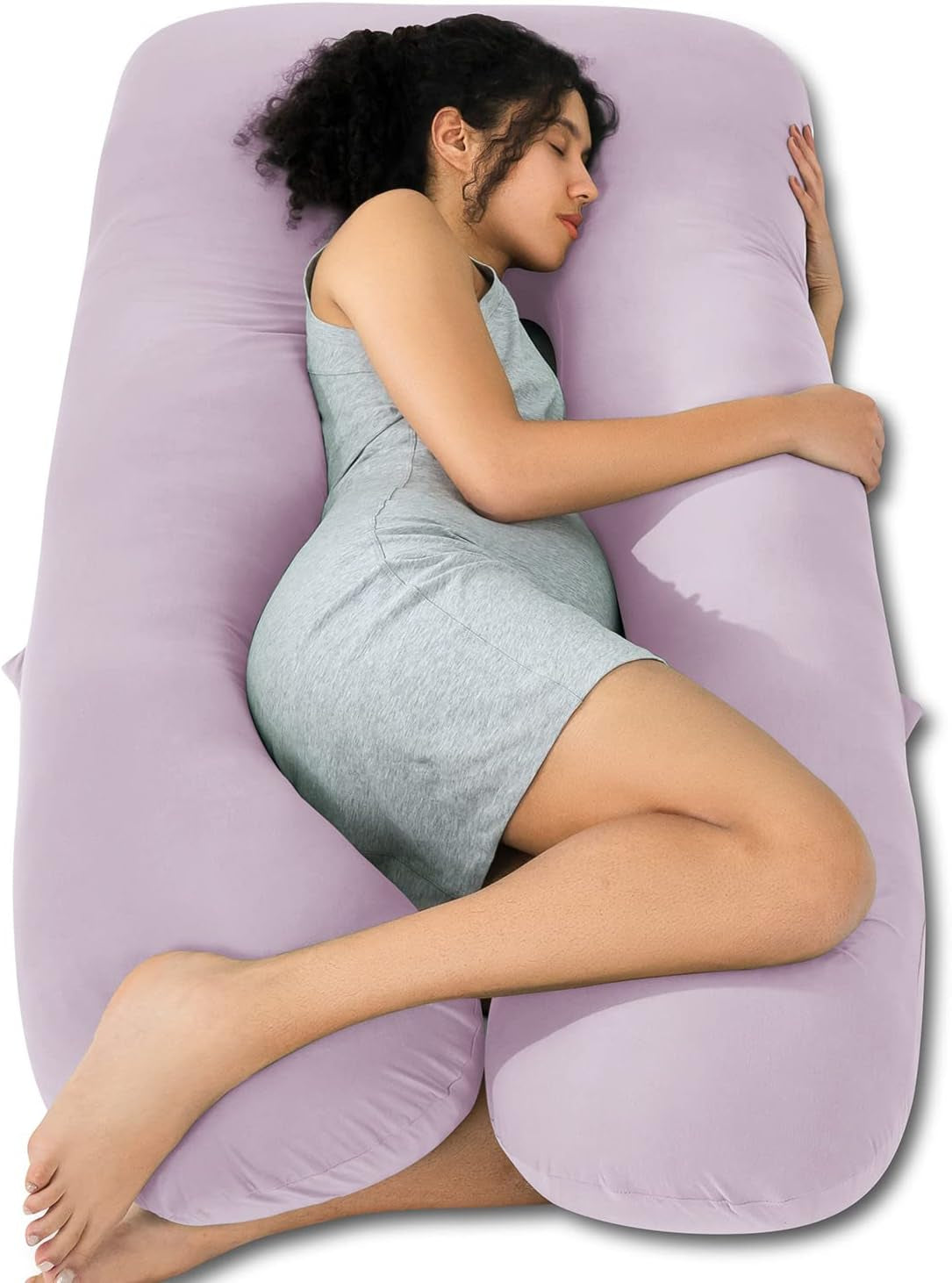 Side view of a pregnant woman hugging a light lavender U-shaped pregnancy pillow while sleeping.