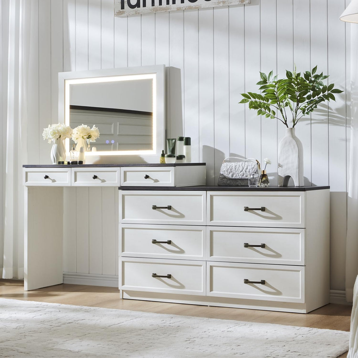 Vanity desk with lit LED mirror and dark tabletop, frontal view styled with vase and accessories