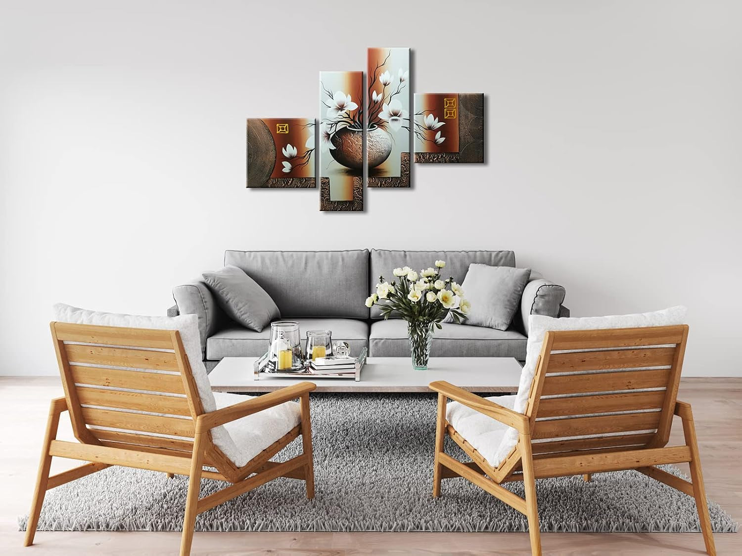 Four-panel floral artwork mounted on a white wall above a grey sofa with wooden accent chairs in a styled living room.