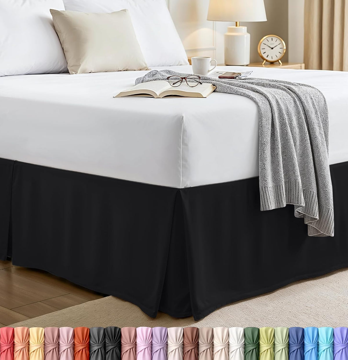 Bedroom corner with a black pleated bed skirt under a white mattress, bedside lamp visible.