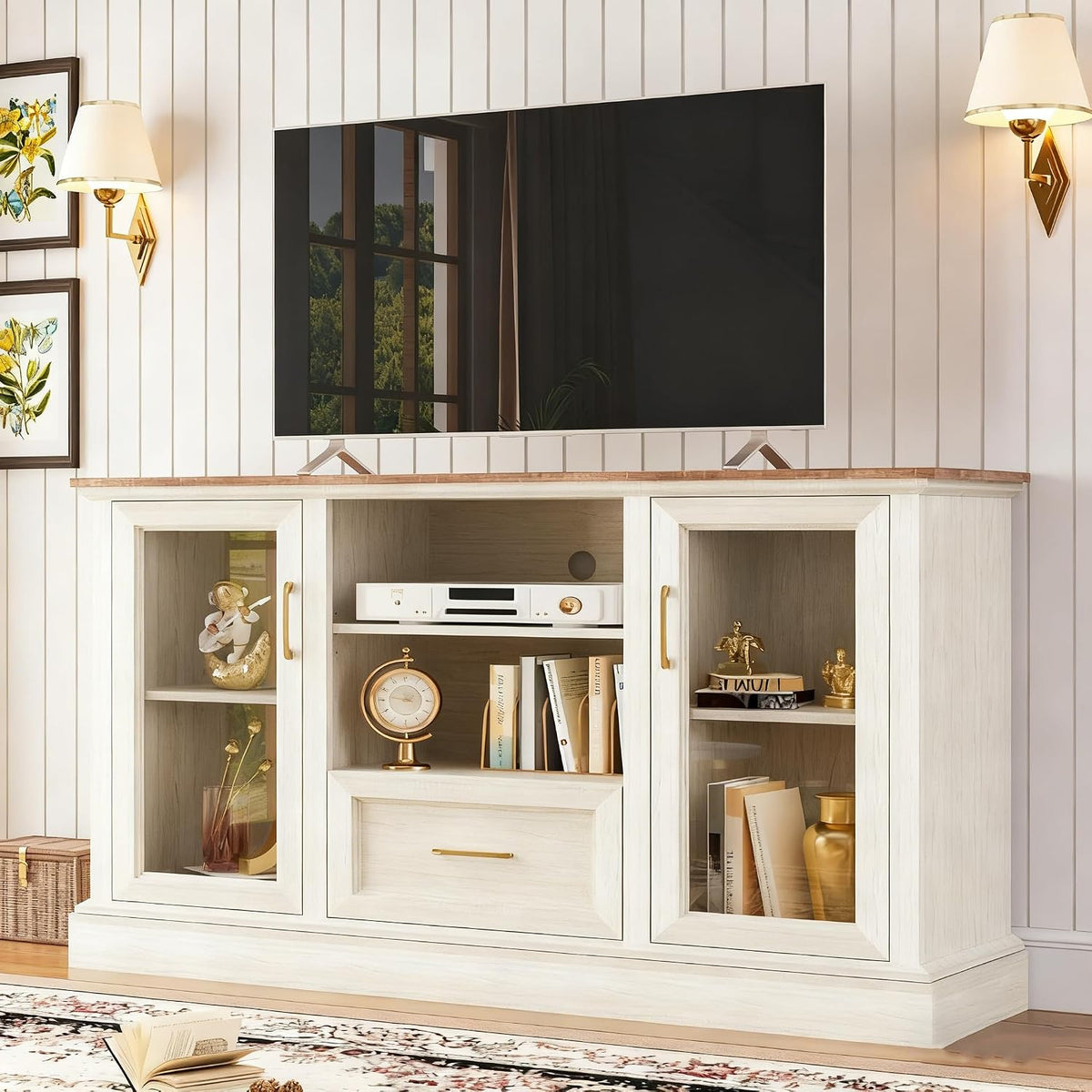 Front-facing scene of the rustic white TV stand beneath a flat screen, with glass-front cabinets and center drawer displayed.