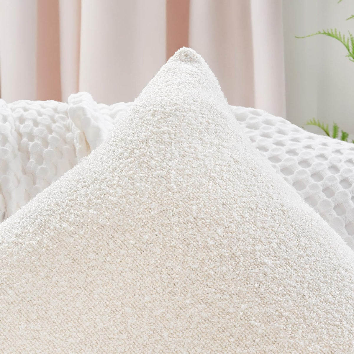 Close-up of an ivory boucle pillow corner and peak showing fabric loops