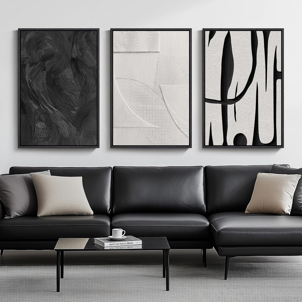 Three framed black-and-white abstract canvas panels hung side-by-side over a black leather sofa, straight-on view