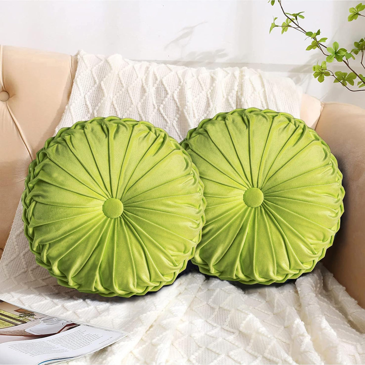 Pair of lime-green round ruched pillows placed on a sofa arm with a textured cream blanket