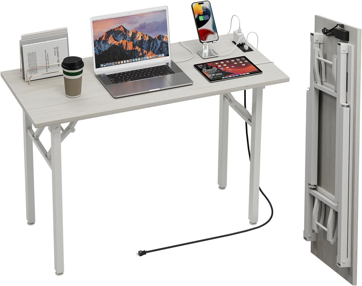 Desk shown with laptop, phone and tablet and an integrated power strip on the top edge; folded legs and power cord visible.