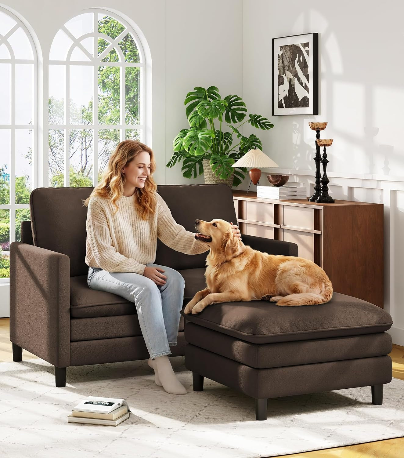 Brown small sofa paired with a matching ottoman; woman pets a golden retriever on the ottoman.