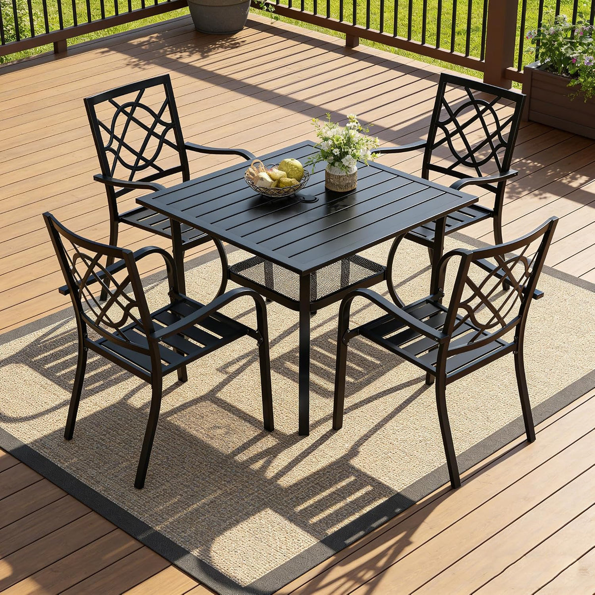 Black metal 5-piece patio dining set arranged on a wood-deck with the 37-inch square table and four chairs on a rug.