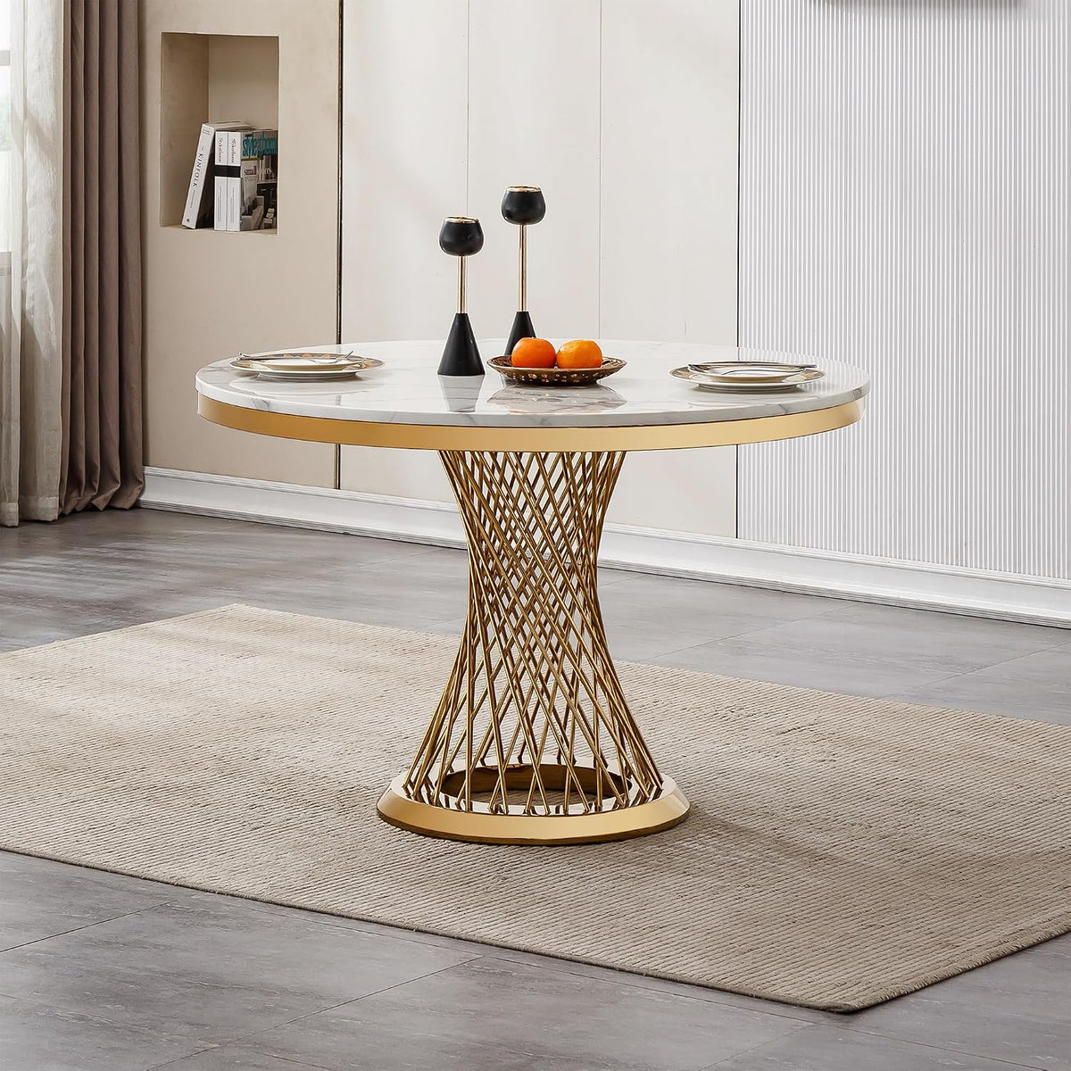 Angled view of marble-top table with gold spiral base, two black candlesticks and a fruit bowl on top