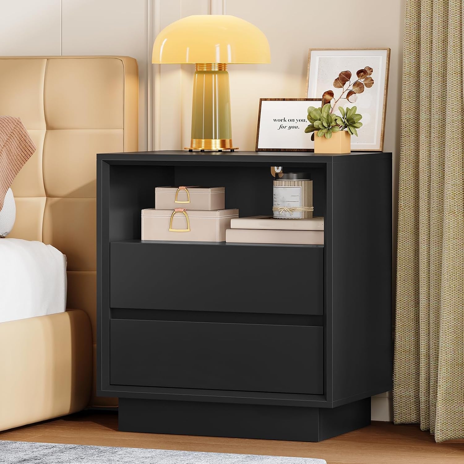 Black nightstand staged beside a bed with decorative lamp and boxes visible on the open shelf