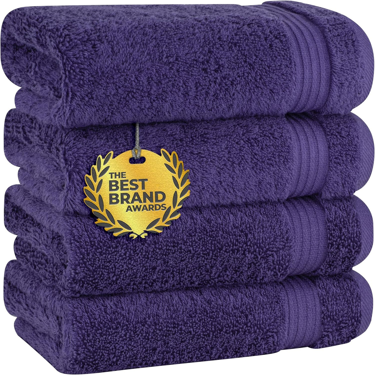 Four deep purple towels stacked neatly with a round gold award medallion hanging on the front.