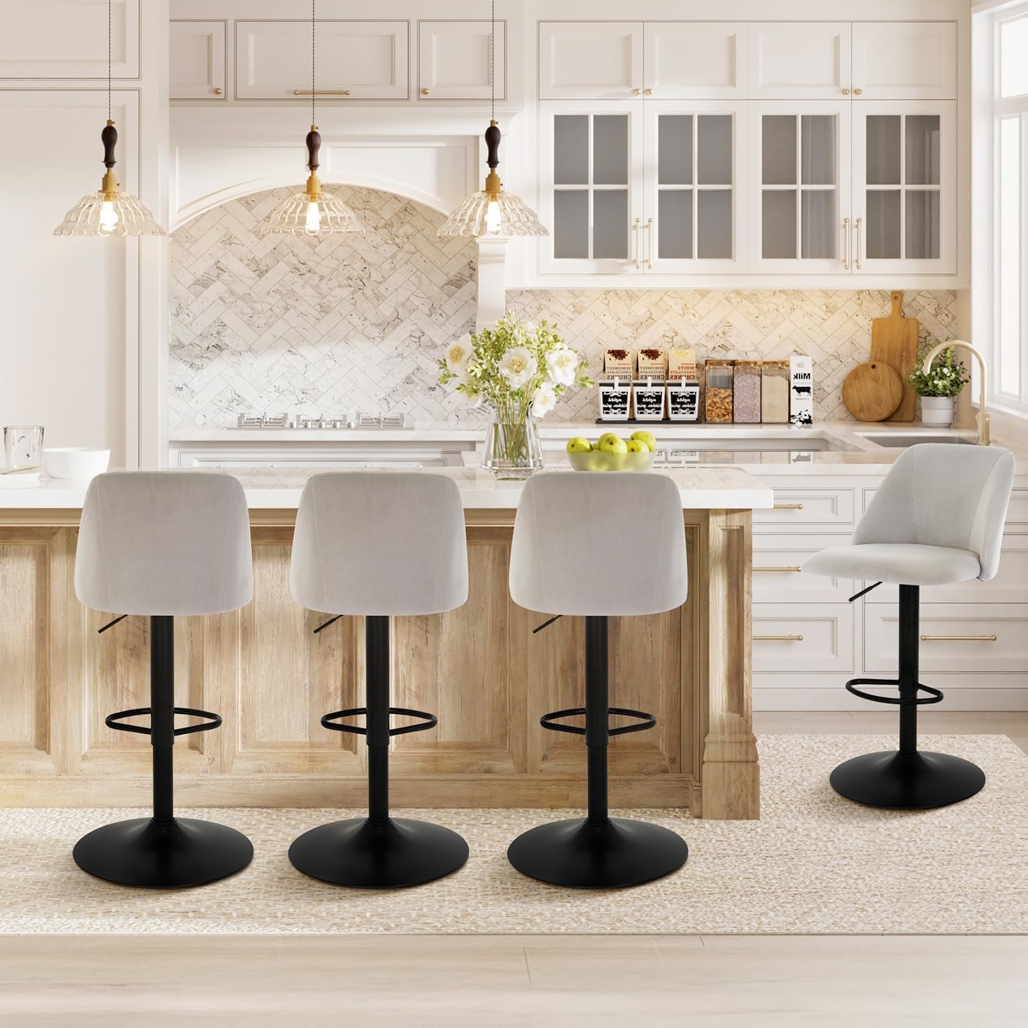 Rear view of three light-gray stools at the island and one stool rotated to face the camera on the right