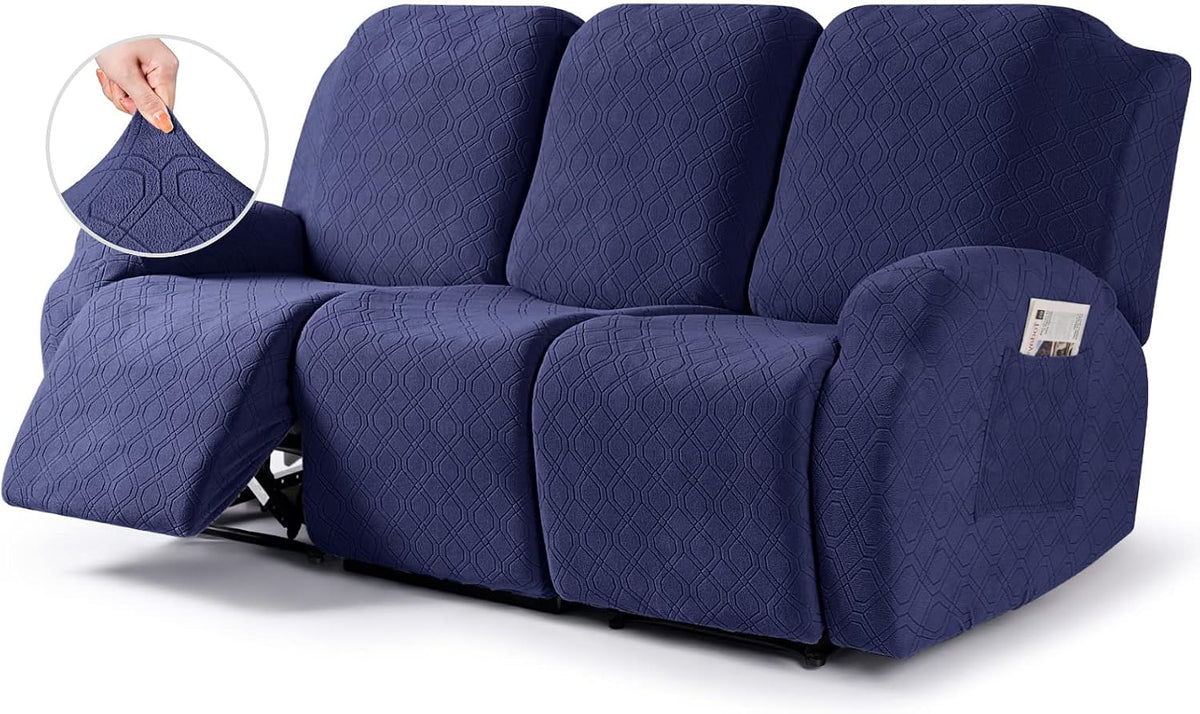 Three-seat reclining sofa in navy blue textured slipcover with one footrest extended and visible arm pocket.