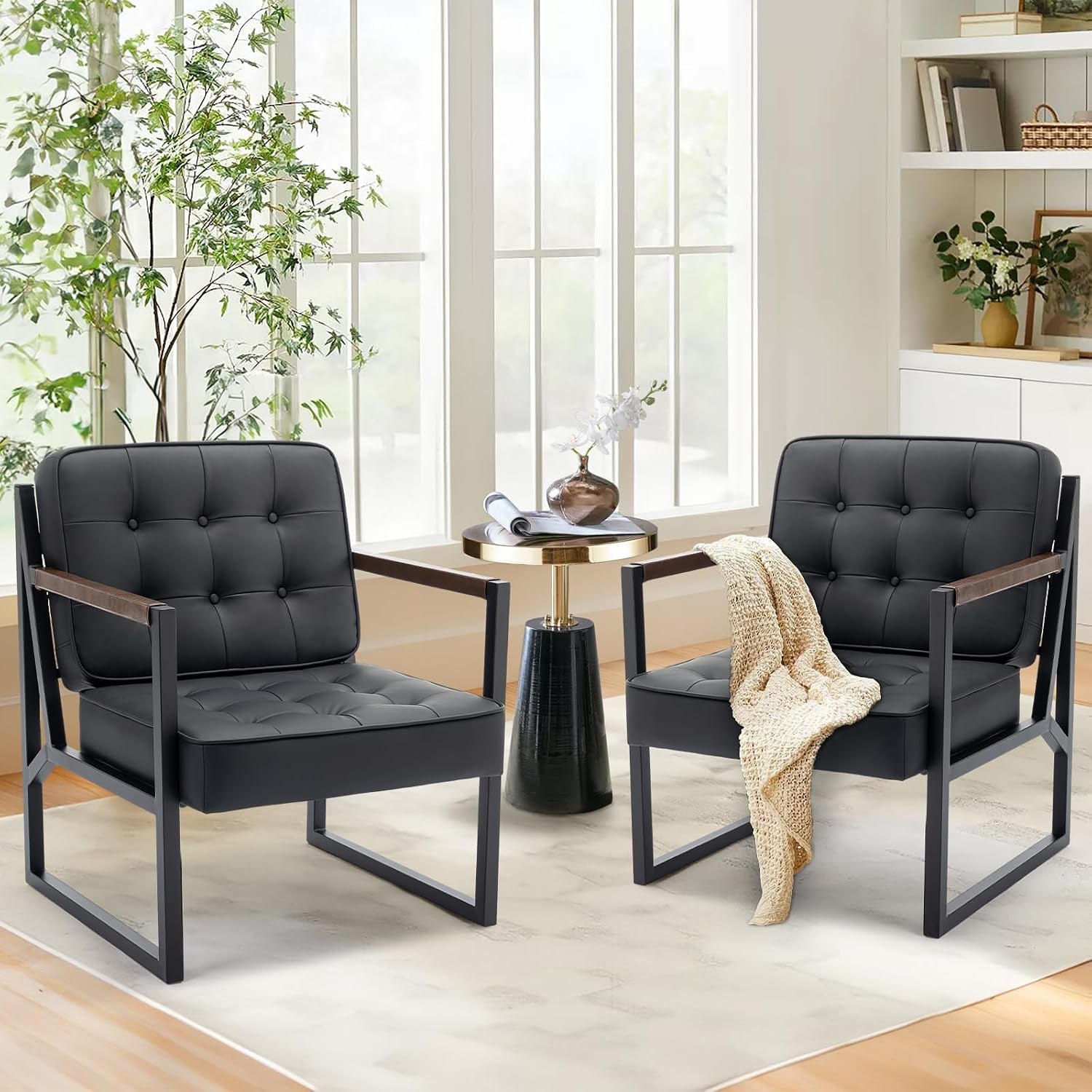 Two black tufted faux leather accent chairs with metal frames shown in a bright living room setting