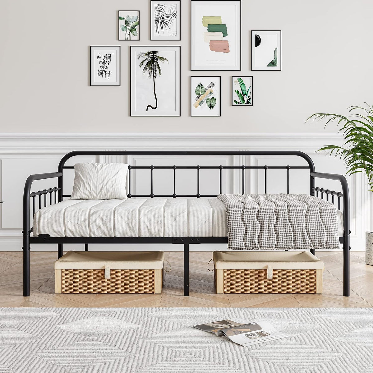 Front-facing view of black metal daybed centered in a living room with storage baskets placed beneath the elevated frame