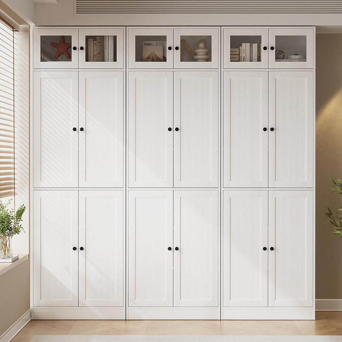 Full-front view of the white bookcase showing symmetrical closed doors and black round knobs.
