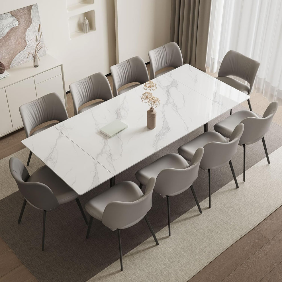 Rectangular white sintered stone dining table extended with grey chairs angled overhead view