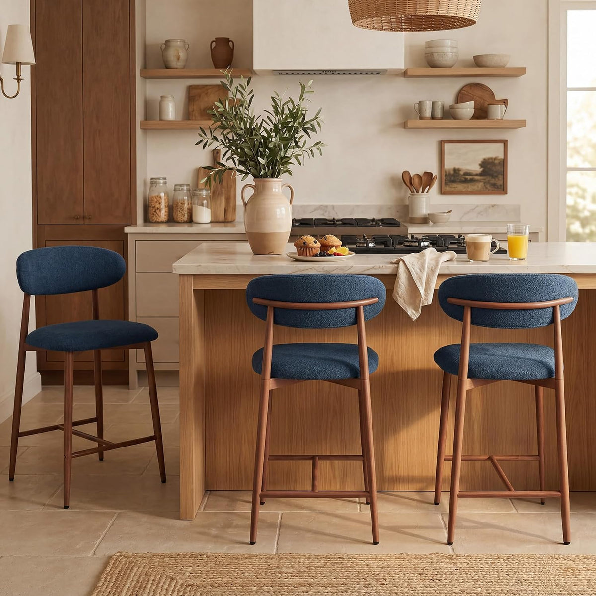 Three navy upholstered counter stools at a kitchen island with two facing forward and one angled left.