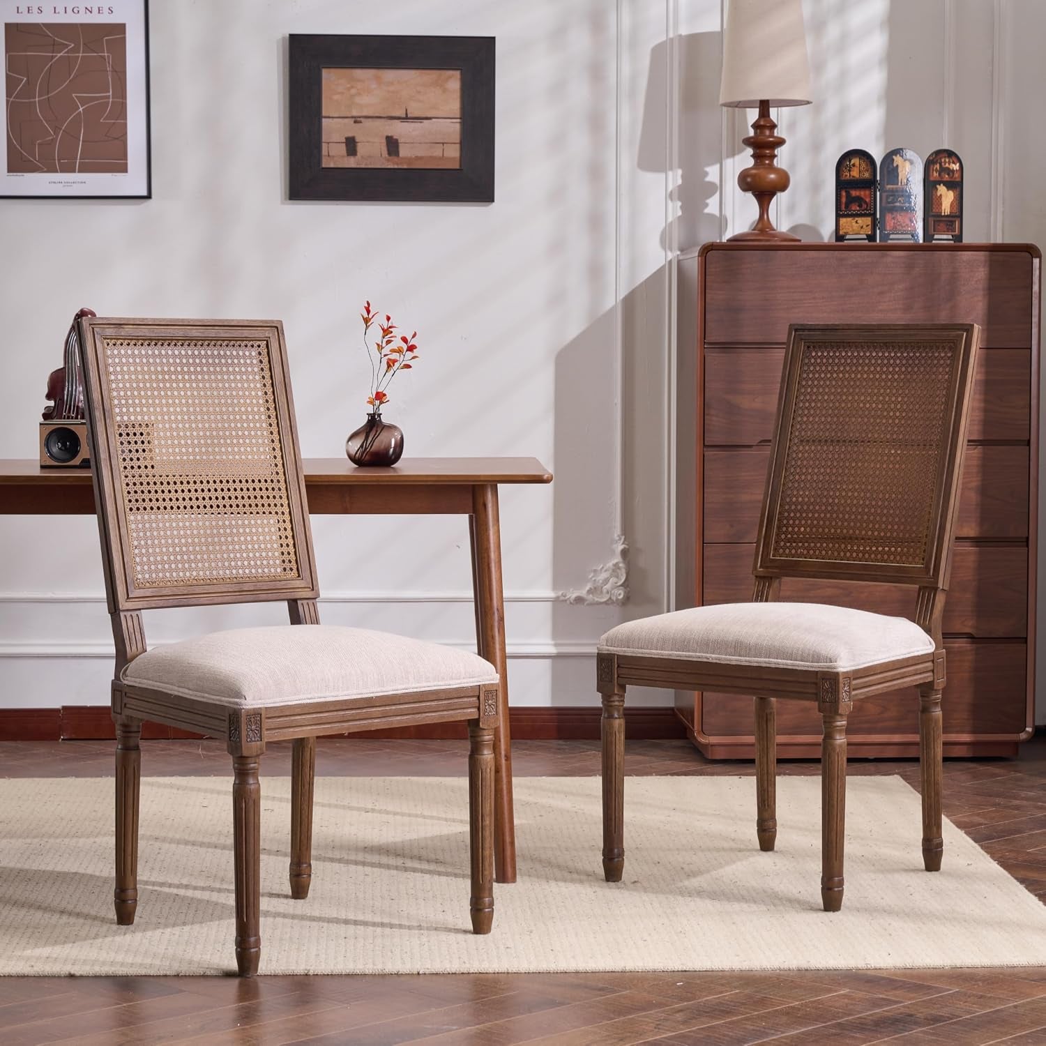 Beige fabric dining chairs with handwoven cane backs and walnut wood frame in a styled dining room, two-chair view