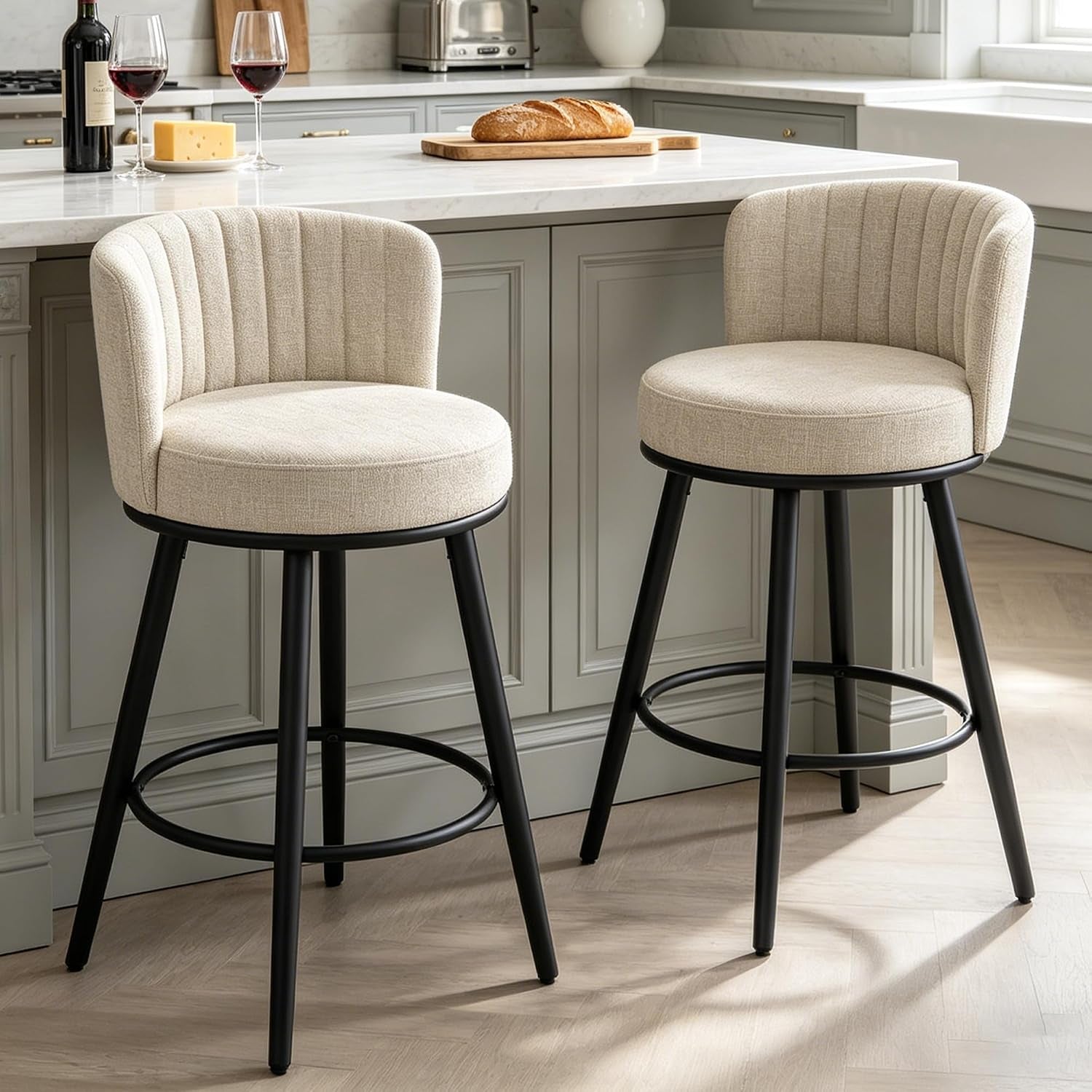 Pair of beige upholstered 28-inch swivel bar stools at a marble kitchen island, angled kitchen setting