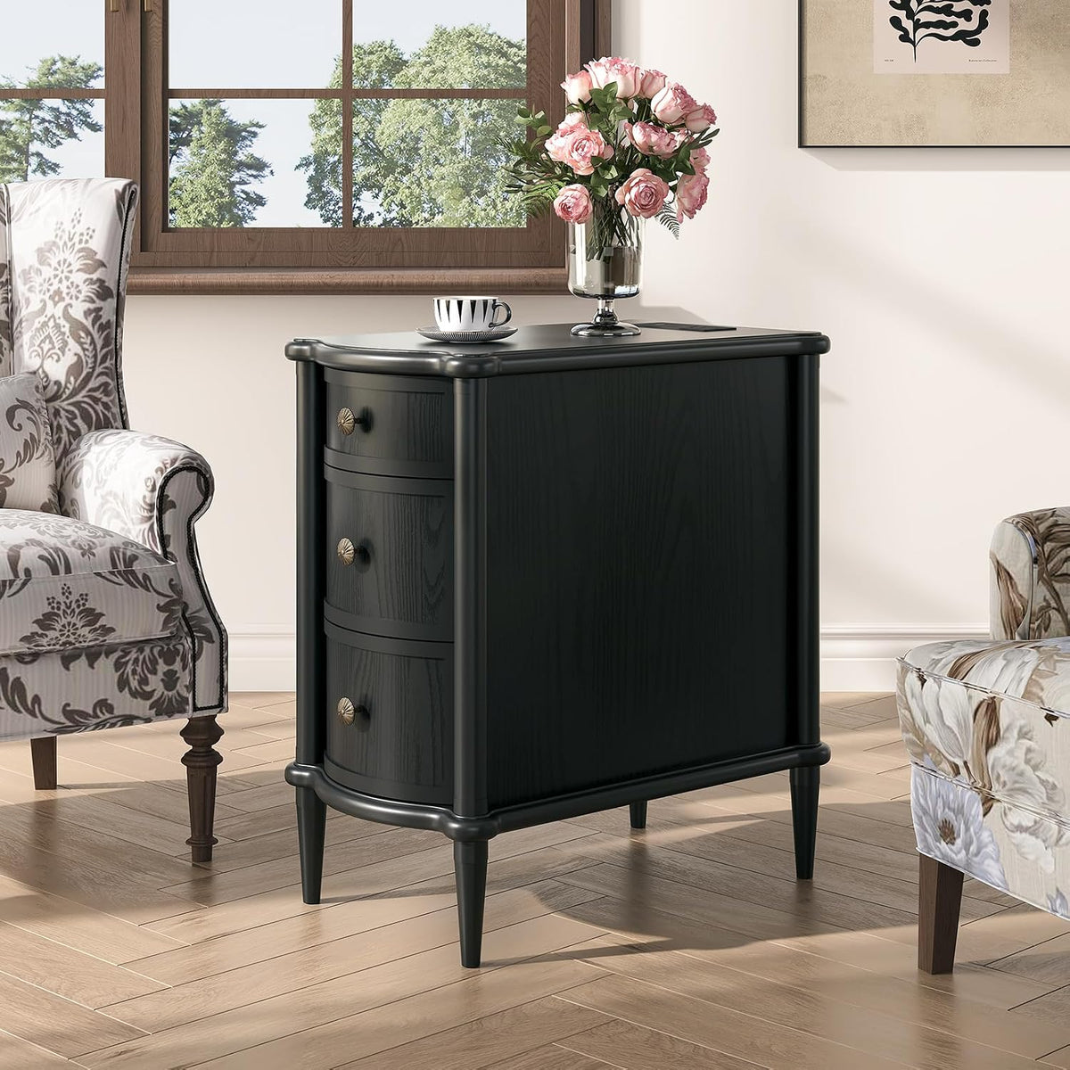 Three-quarter view of a black fluted nightstand with rounded front drawers and decorative knobs.