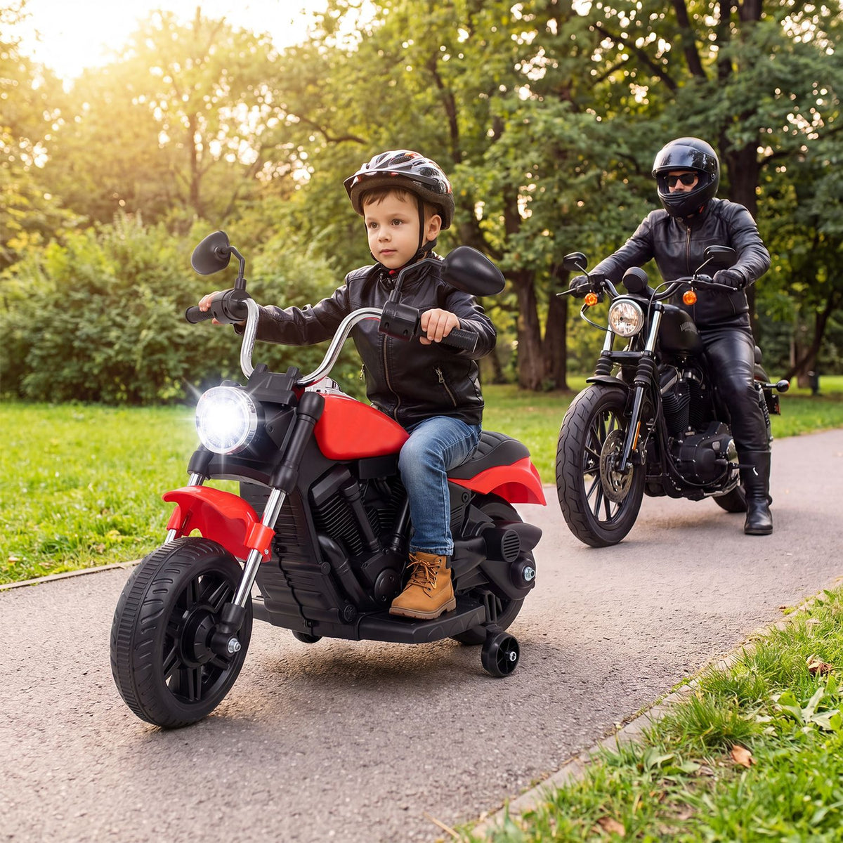Child rides a red-and-black toy motorcycle along a park path with an adult following on a motorcycle.