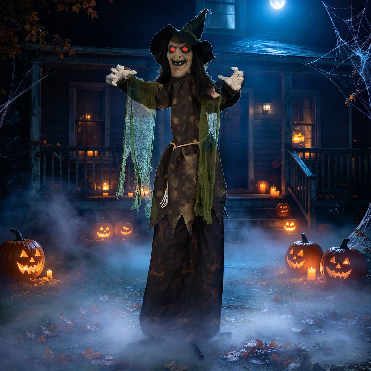 A witch decoration stands in a foggy yard, framed by glowing jack-o'-lanterns and a dark house.