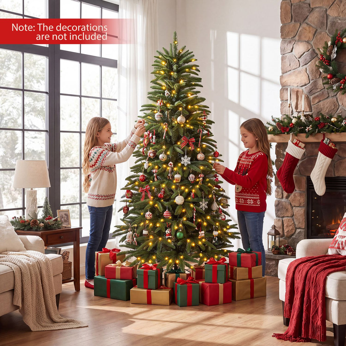 Lit decorated Christmas tree with gift boxes as two people trim it