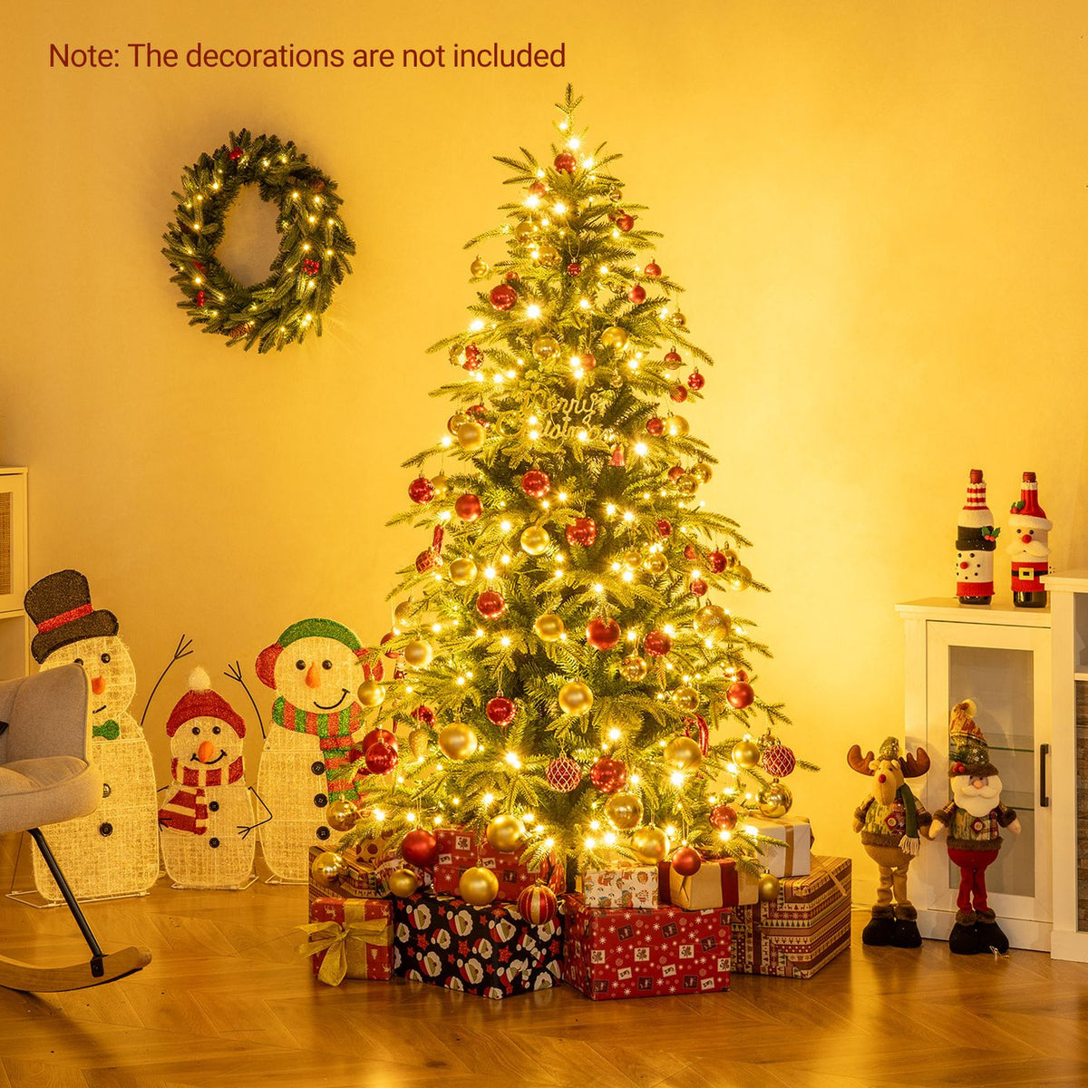 A glowing Christmas tree decorated with red and gold ornaments and gifts in a warmly lit room.