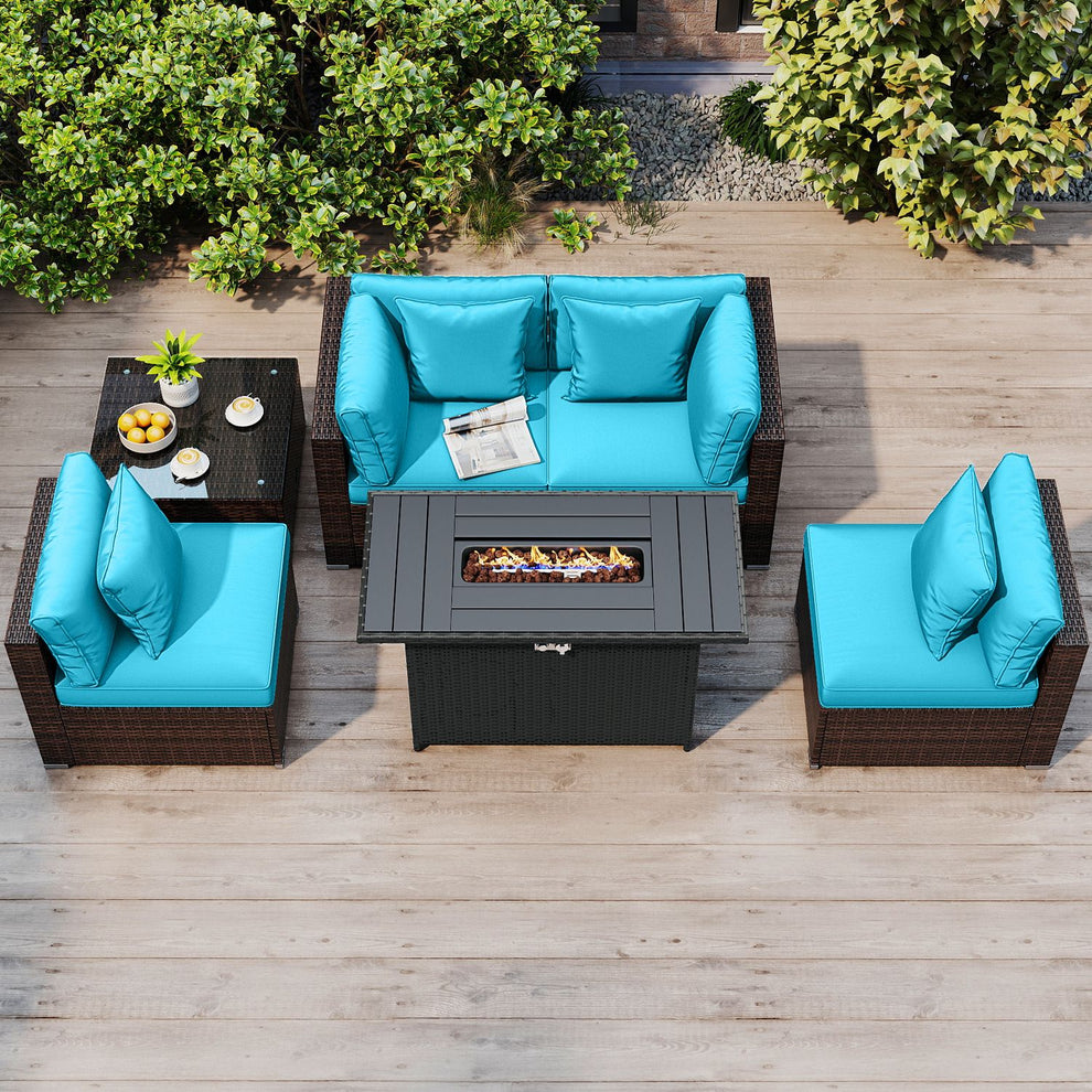 Overhead view of turquoise cushioned patio seating around a rectangular fire pit table on a wooden deck.