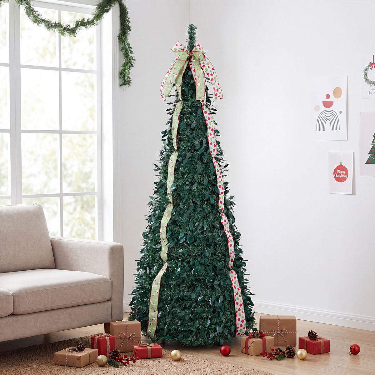 Ribbon-trimmed green Christmas tree beside a beige sofa, with wrapped gifts arranged around its base.